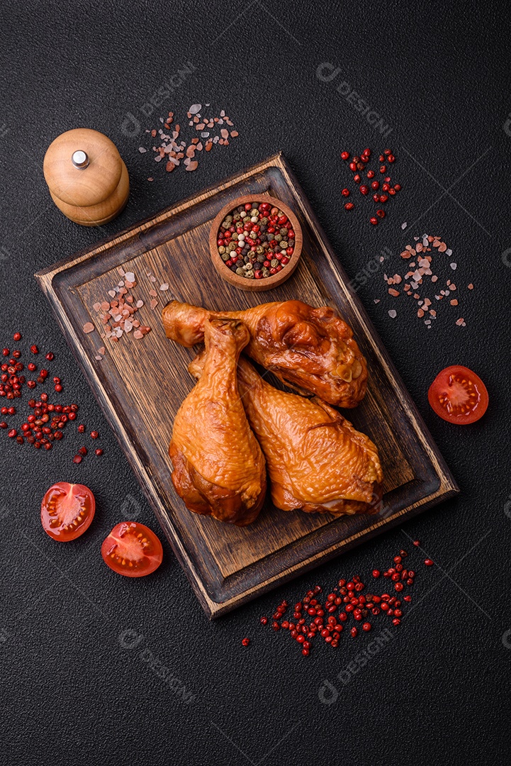 Deliciosas pernas de frango assadas na grelha com sal, especiarias e ervas sobre um fundo de concreto texturizado