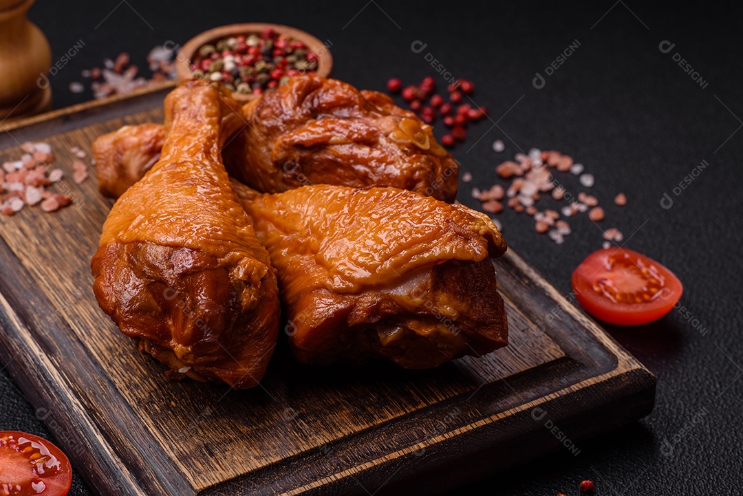 Deliciosas pernas de frango assadas na grelha com sal, especiarias e ervas sobre um fundo de concreto texturizado