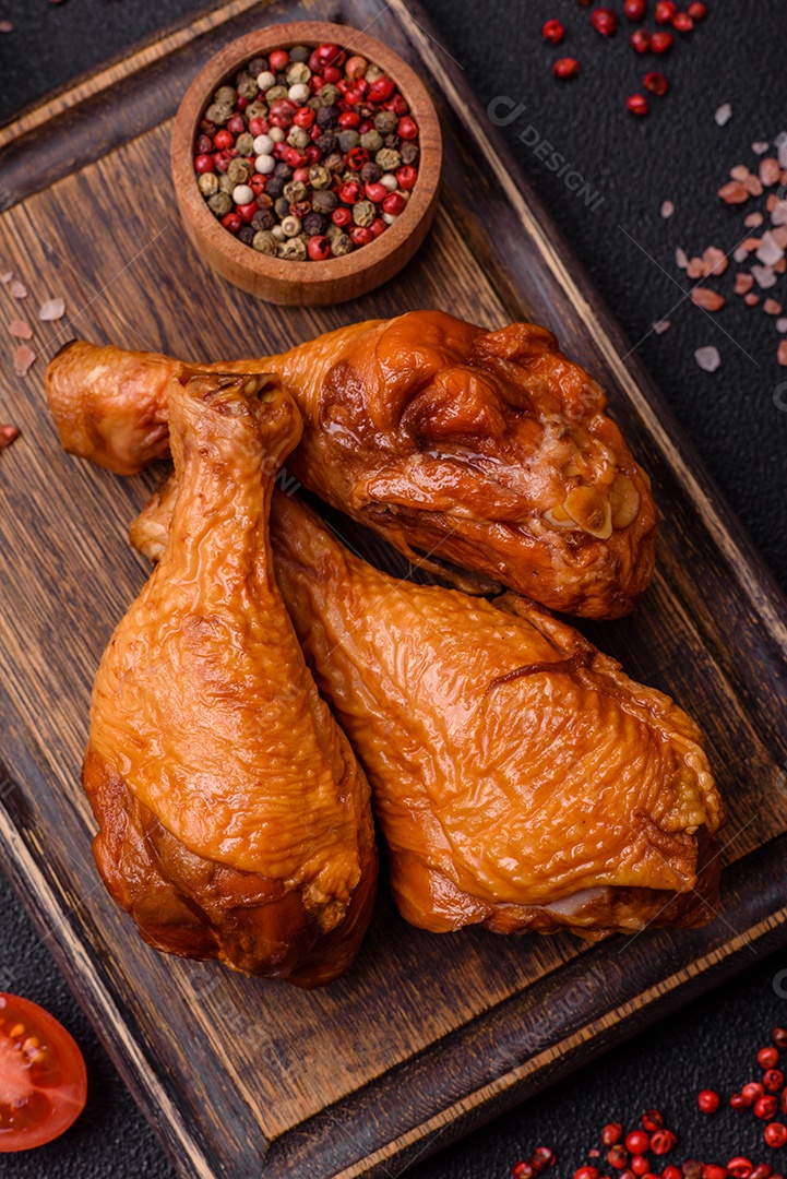 Deliciosas pernas de frango assadas na grelha com sal, especiarias e ervas sobre um fundo de concreto texturizado