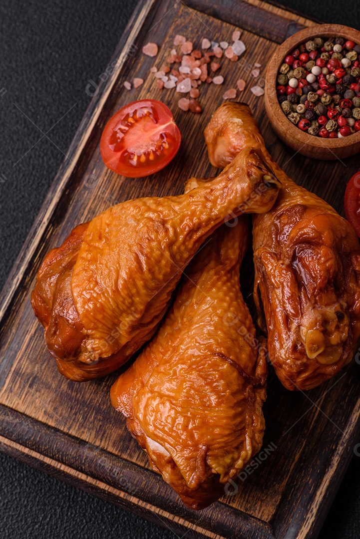 Deliciosas pernas de frango assadas na grelha com sal, especiarias e ervas sobre um fundo de concreto texturizado