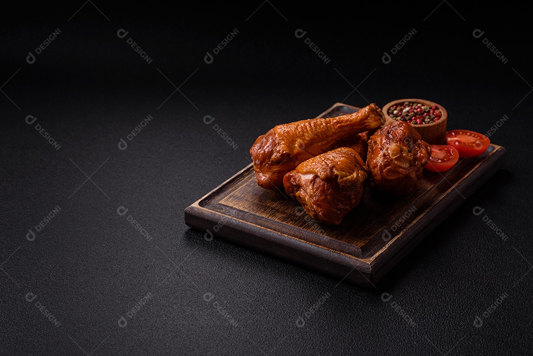 Deliciosas pernas de frango assadas na grelha com sal, especiarias e ervas sobre um fundo de concreto texturizado