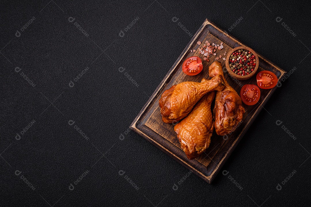 Deliciosas pernas de frango assadas na grelha com sal, especiarias e ervas sobre um fundo de concreto texturizado