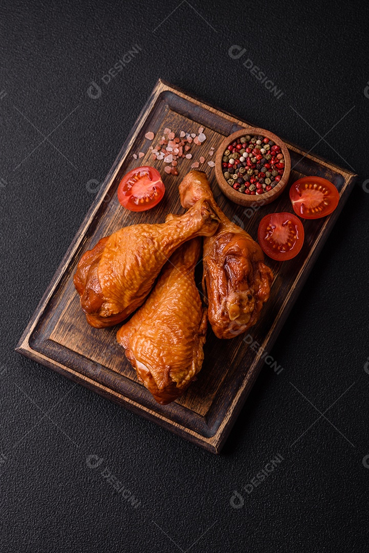 Deliciosas pernas de frango assadas na grelha com sal, especiarias e ervas sobre um fundo de concreto texturizado