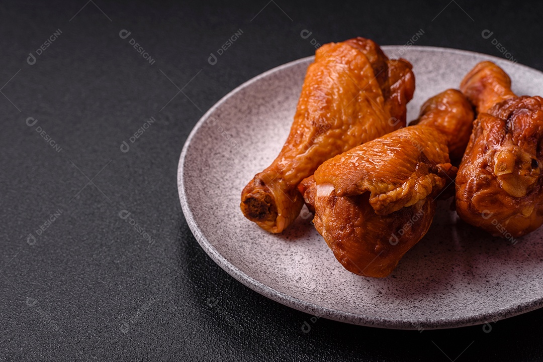 Deliciosas pernas de frango assadas na grelha com sal, especiarias e ervas sobre um fundo de concreto texturizado