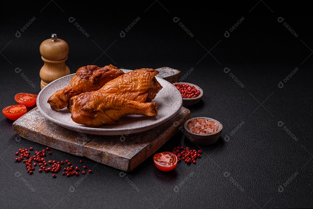 Deliciosas pernas de frango assadas na grelha com sal, especiarias e ervas sobre um fundo de concreto texturizado