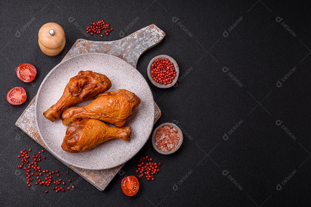 Deliciosas pernas de frango assadas na grelha com sal, especiarias e ervas sobre um fundo de concreto texturizado