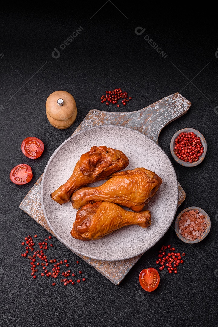 Deliciosas pernas de frango assadas na grelha com sal, especiarias e ervas sobre um fundo de concreto texturizado