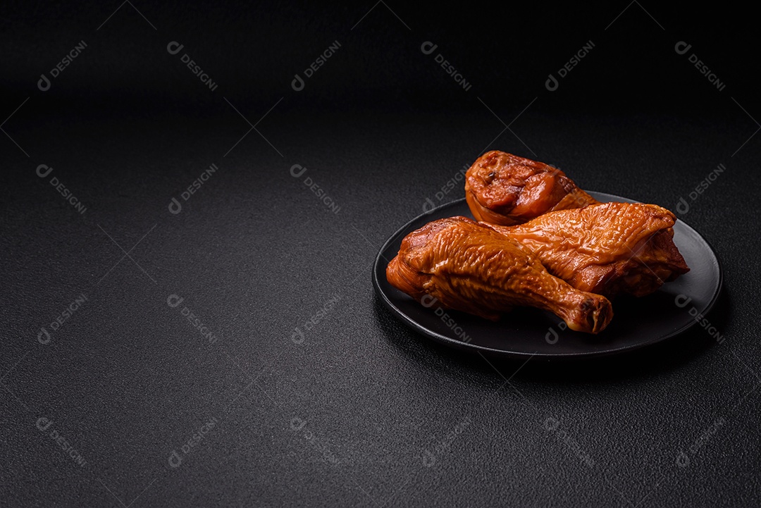 Deliciosas pernas de frango assadas na grelha com sal, especiarias e ervas sobre um fundo de concreto texturizado