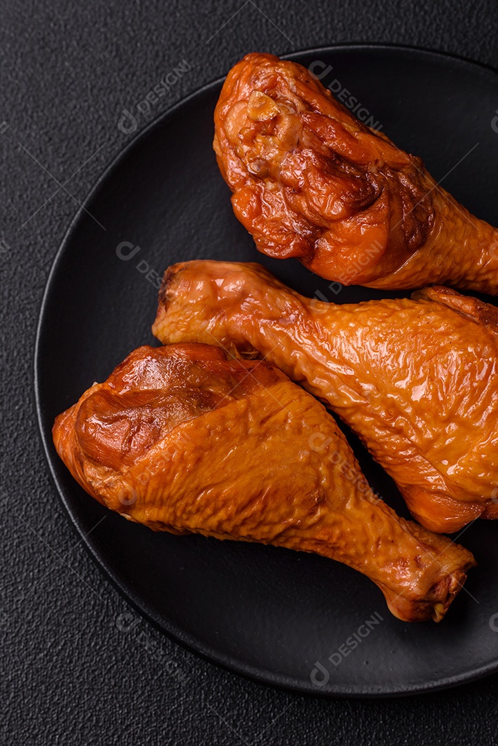Deliciosas pernas de frango assadas na grelha com sal, especiarias e ervas sobre um fundo de concreto texturizado
