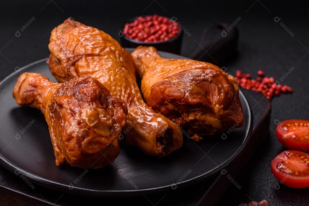 Deliciosas pernas de frango assadas na grelha com sal, especiarias e ervas sobre um fundo de concreto texturizado