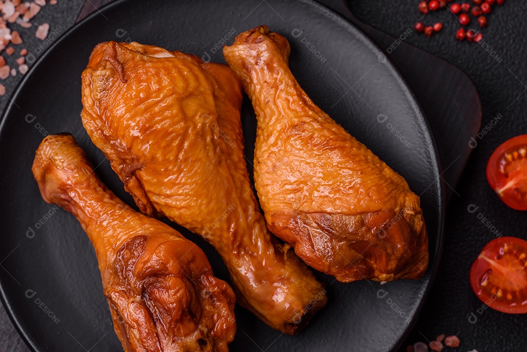 Deliciosas pernas de frango assadas na grelha com sal, especiarias e ervas sobre um fundo de concreto texturizado