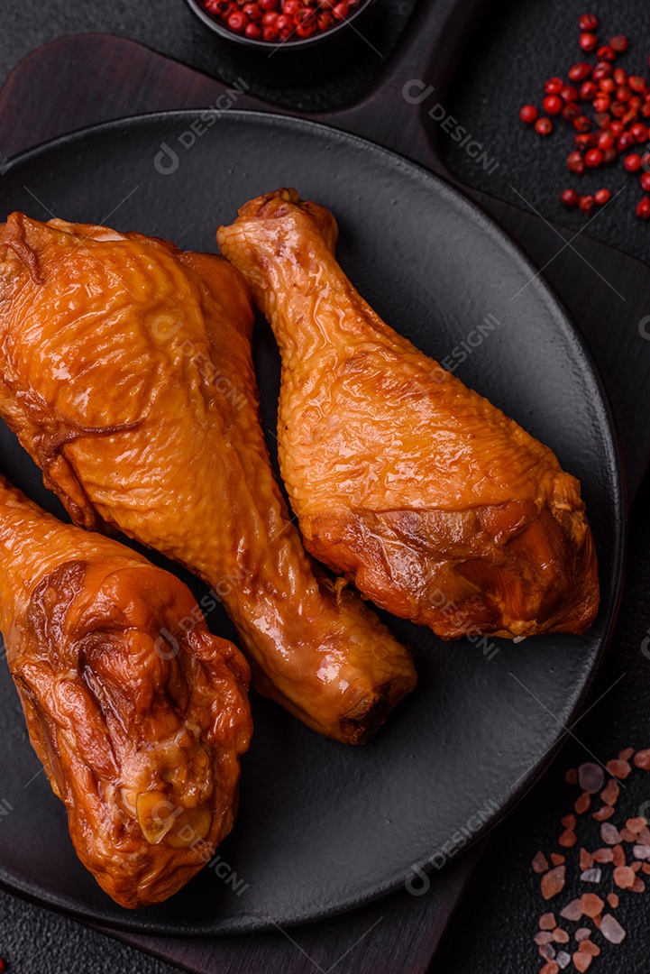 Deliciosas pernas de frango assadas na grelha com sal, especiarias e ervas sobre um fundo de concreto texturizado