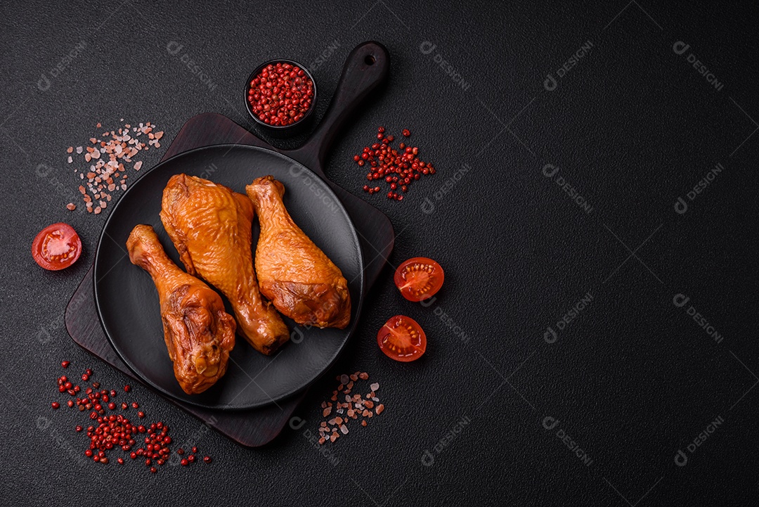 Deliciosas pernas de frango assadas na grelha com sal, especiarias e ervas sobre um fundo de concreto texturizado