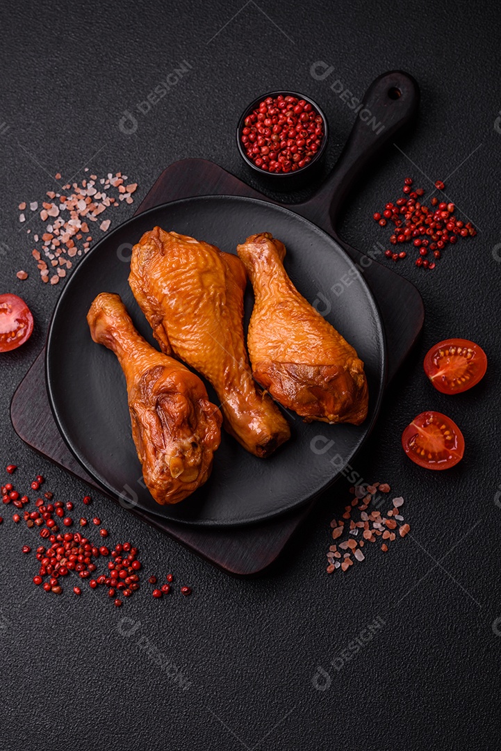 Deliciosas pernas de frango assadas na grelha com sal, especiarias e ervas sobre um fundo de concreto texturizado