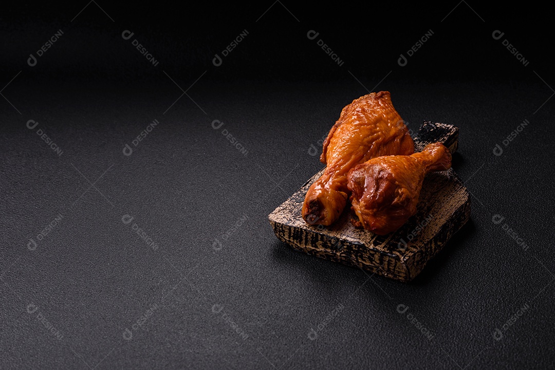 Deliciosas pernas de frango assadas na grelha com sal, especiarias e ervas sobre um fundo de concreto texturizado