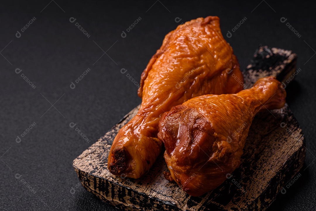 Deliciosas pernas de frango assadas na grelha com sal, especiarias e ervas sobre um fundo de concreto texturizado