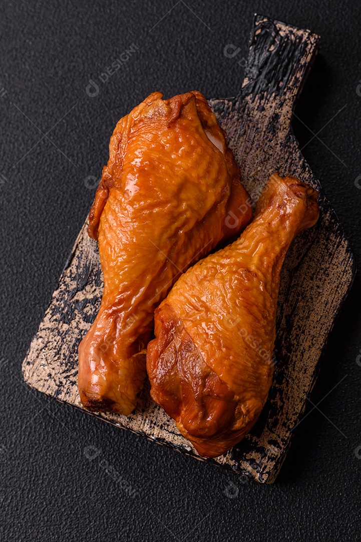 Deliciosas pernas de frango assadas na grelha com sal, especiarias e ervas sobre um fundo de concreto texturizado