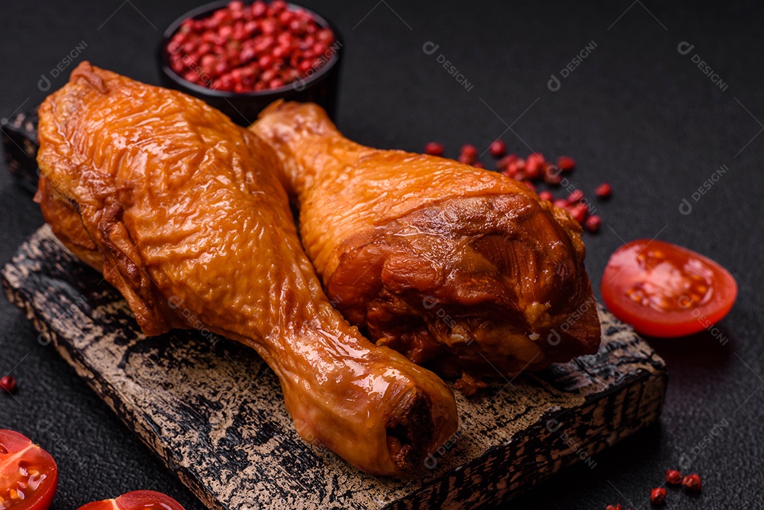 Deliciosas pernas de frango assadas na grelha com sal, especiarias e ervas sobre um fundo de concreto texturizado