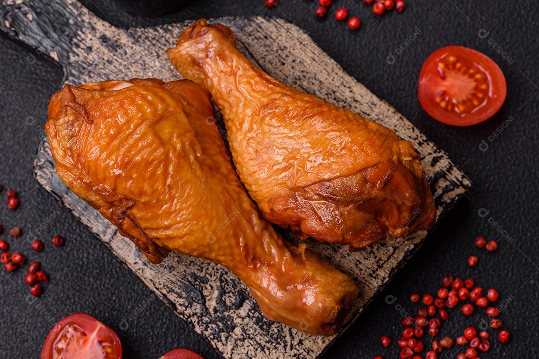 Deliciosas pernas de frango assadas na grelha com sal, especiarias e ervas sobre um fundo de concreto texturizado