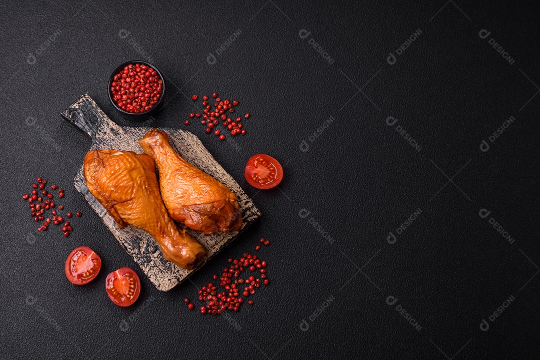 Deliciosas pernas de frango assadas na grelha com sal, especiarias e ervas sobre um fundo de concreto texturizado