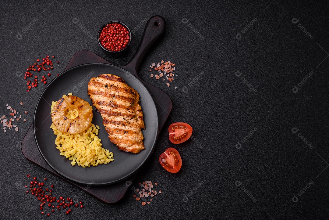 Delicioso filé de frango grelhado fresco com especiarias e ervas em um fundo escuro de concreto. Um prato cozido no fogo