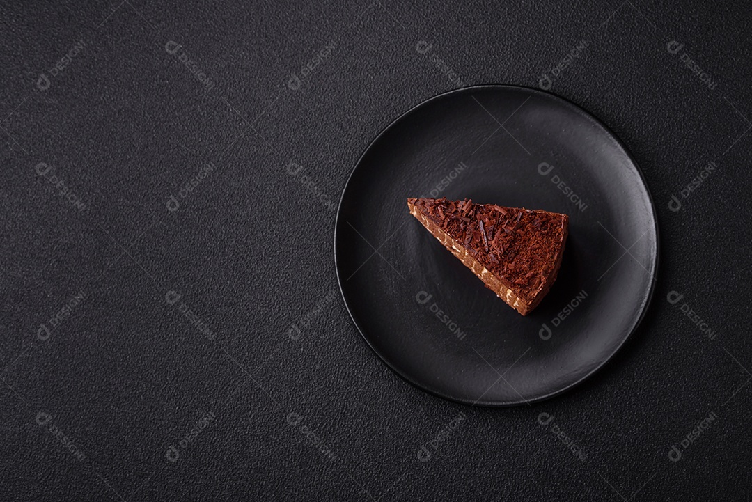 Delicioso bolo de queijo fresco ou snickers com creme e nozes em uma placa cerâmica sobre um fundo escuro de concreto