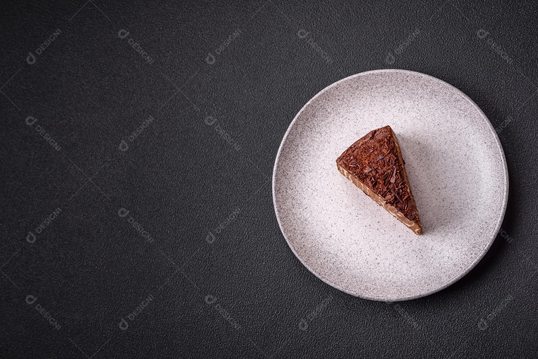 Delicioso bolo de queijo fresco ou snickers com creme e nozes em uma placa cerâmica sobre um fundo escuro de concreto