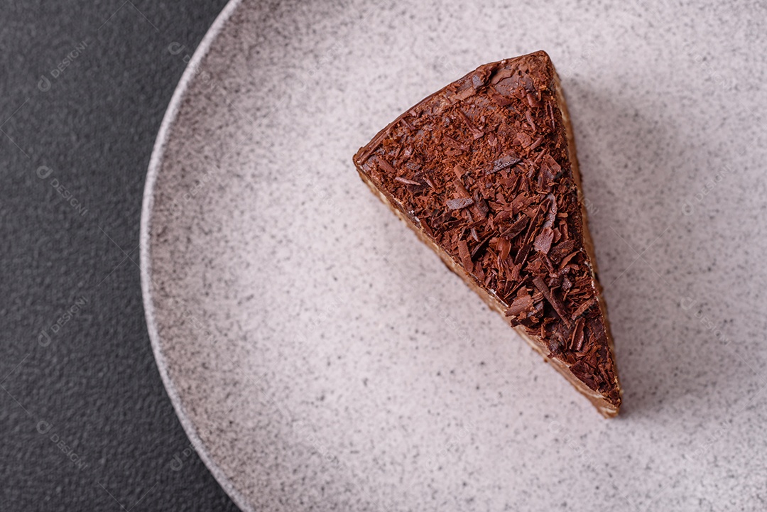 Delicioso bolo de queijo fresco ou snickers com creme e nozes em uma placa cerâmica sobre um fundo escuro de concreto