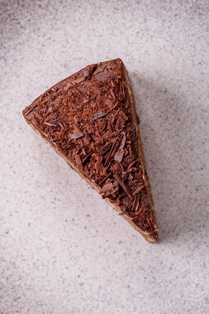 Delicioso bolo de queijo fresco ou snickers com creme e nozes em uma placa cerâmica sobre um fundo escuro de concreto