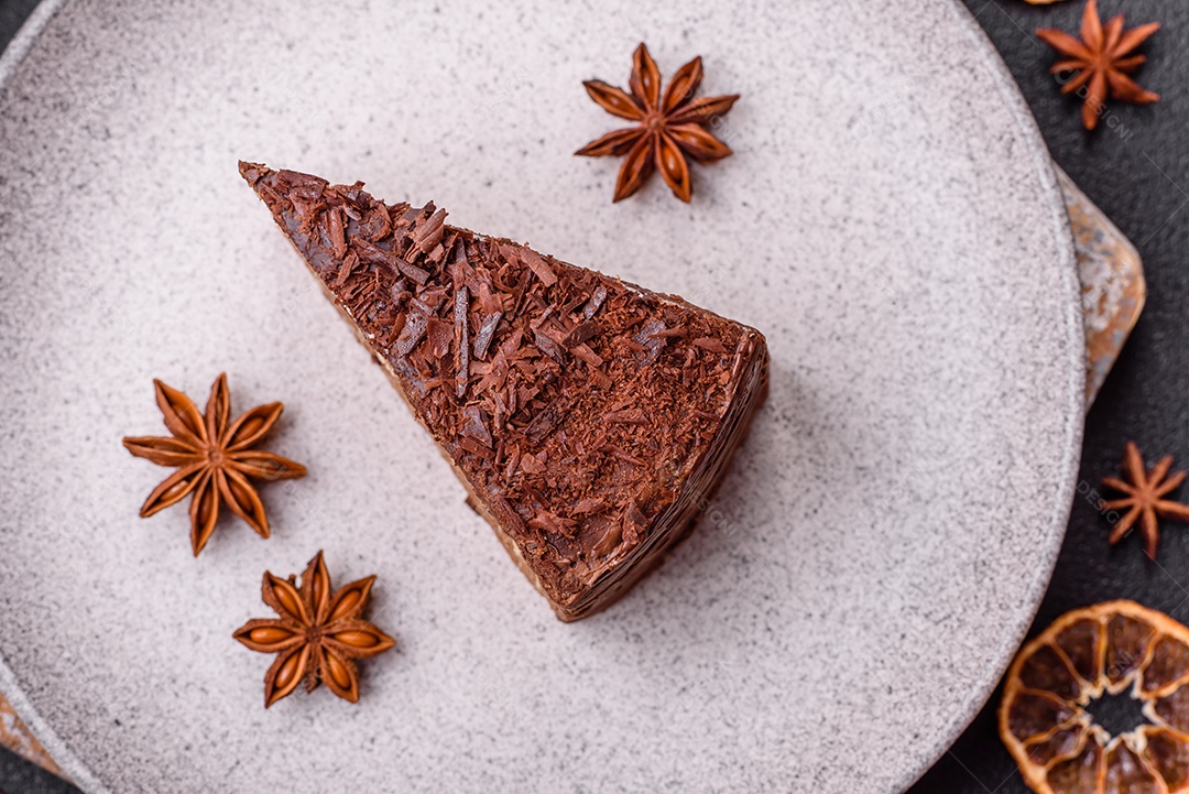 Delicioso bolo de queijo fresco ou snickers com creme e nozes em uma placa cerâmica sobre um fundo escuro de concreto