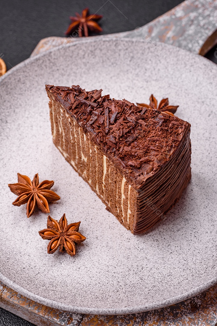 Delicioso bolo de queijo fresco ou snickers com creme e nozes em uma placa cerâmica sobre um fundo escuro de concreto