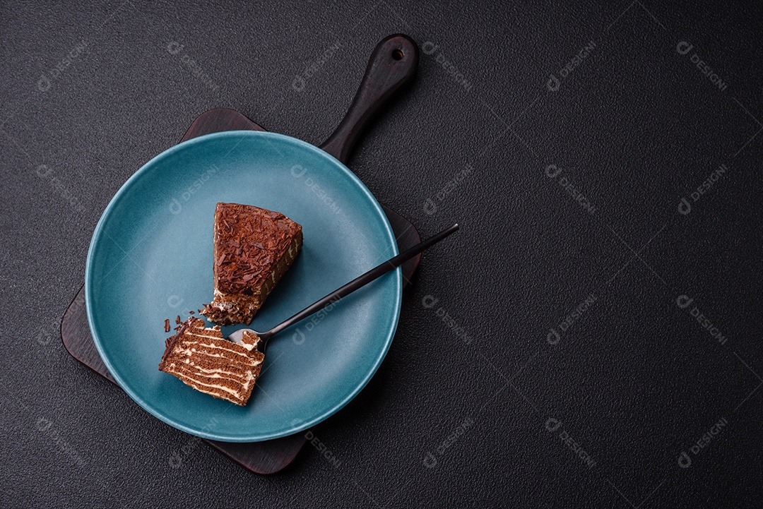 Delicioso bolo de queijo fresco ou snickers com creme e nozes em uma placa cerâmica sobre um fundo escuro de concreto