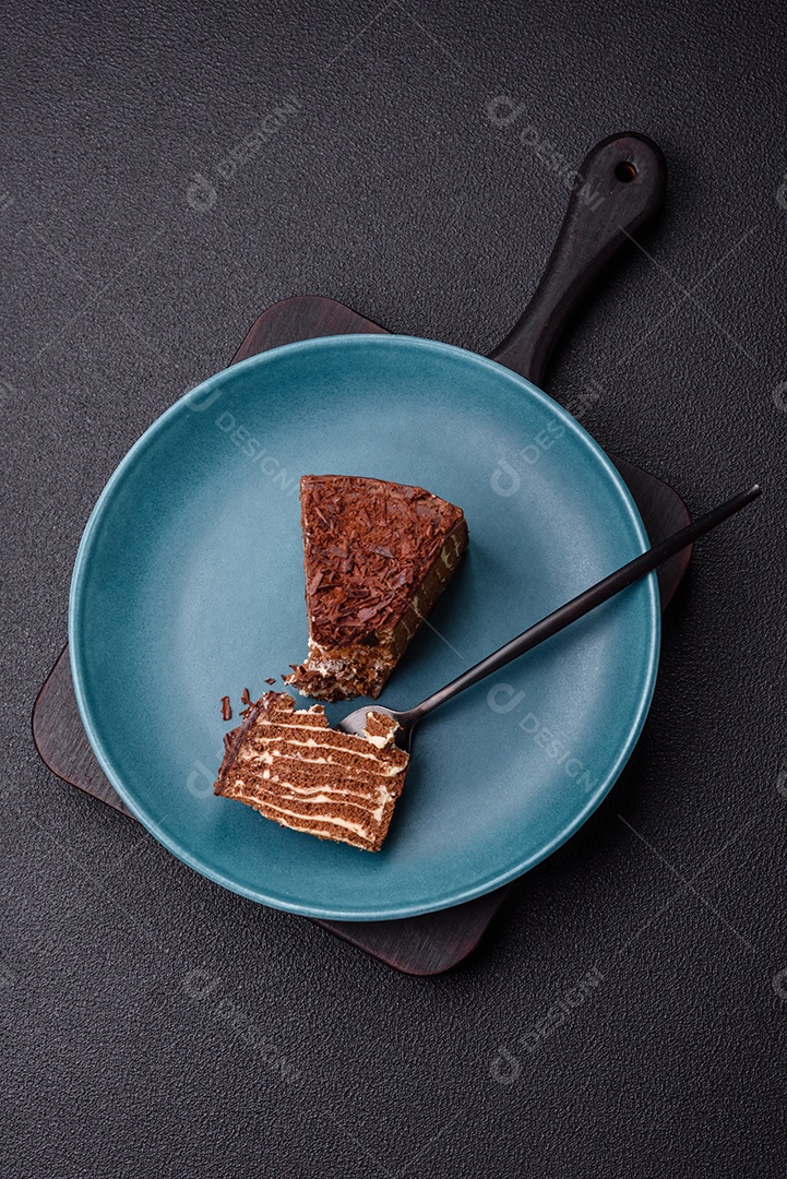 Delicioso bolo de queijo fresco ou snickers com creme e nozes em uma placa cerâmica sobre um fundo escuro de concreto