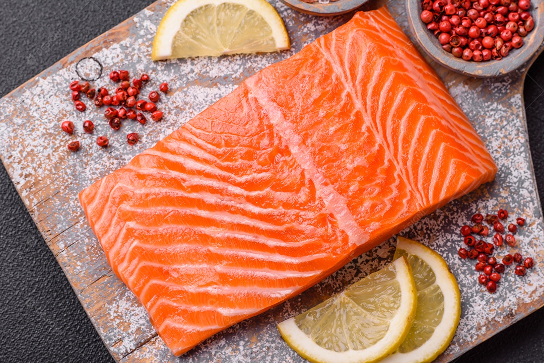 Bife de salmão cru fresco com especiarias e ervas preparadas para cozimento grelhado. Comida saudável de frutos do mar