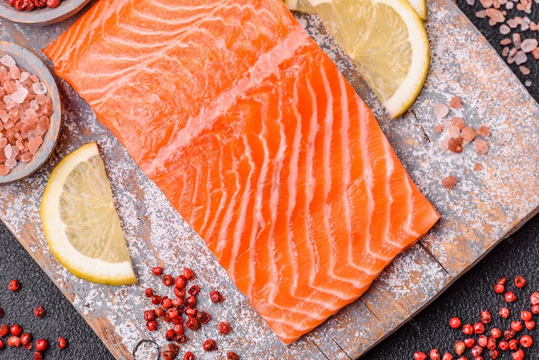 Bife de salmão cru fresco com especiarias e ervas preparadas para cozimento grelhado. Comida saudável de frutos do mar