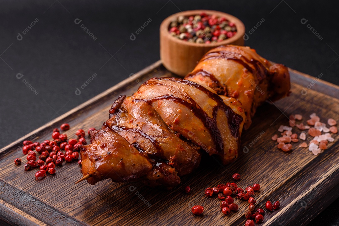 Delicioso kebab de frango ou carne de porco com sal, especiarias e ervas sobre um fundo escuro de concreto