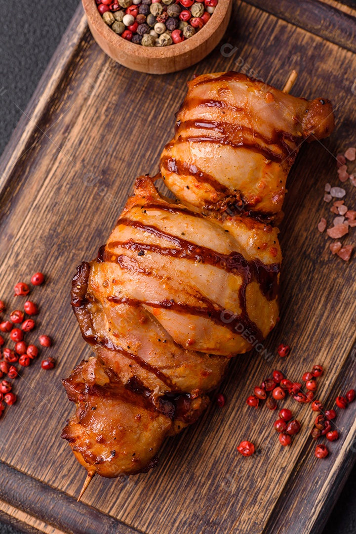 Delicioso kebab de frango ou carne de porco com sal, especiarias e ervas sobre um fundo escuro de concreto