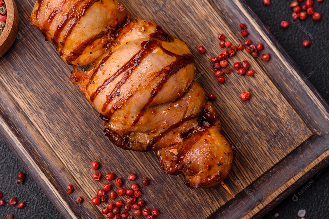 Delicioso kebab de frango ou carne de porco com sal, especiarias e ervas sobre um fundo escuro de concreto