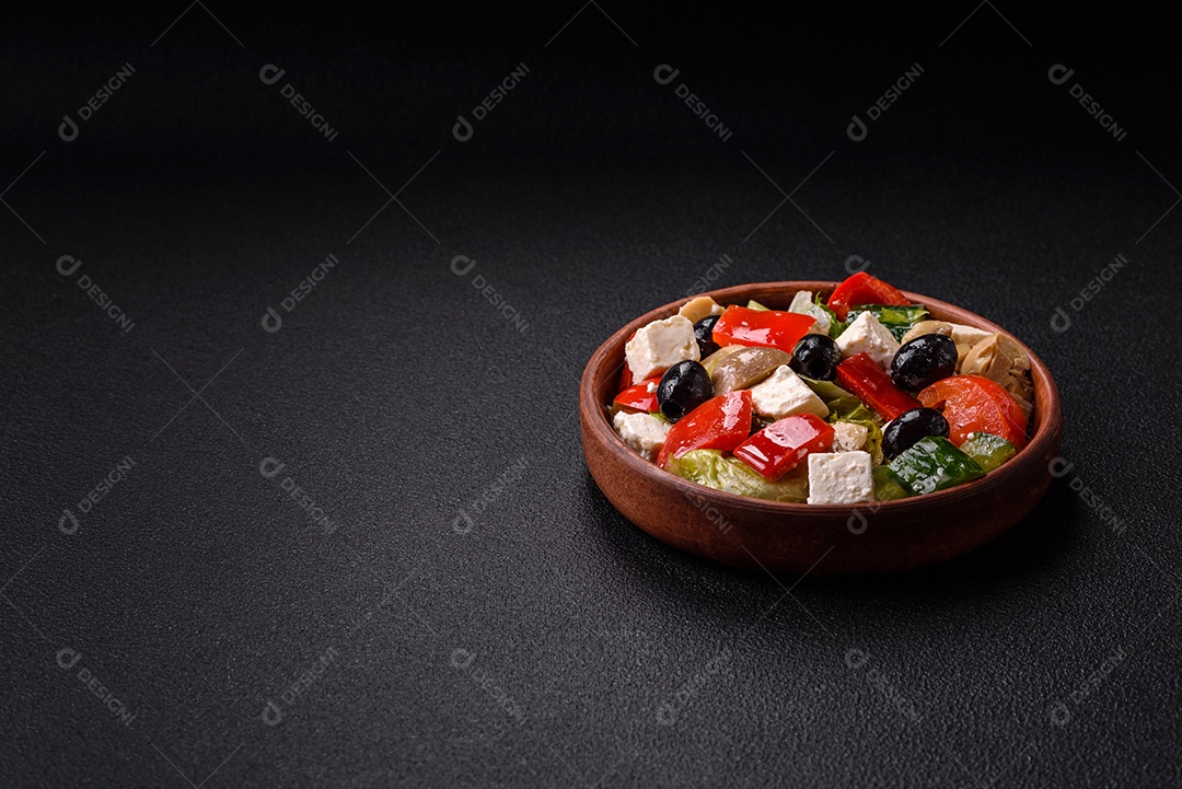 Deliciosa salada fresca e suculenta de pimentão, queijo, azeitonas, tomates, pepinos com sal e especiarias sobre um fundo escuro de concreto