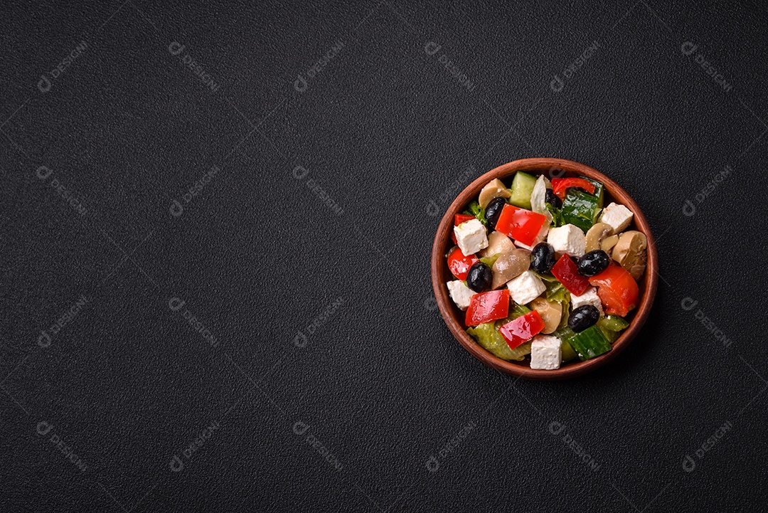 Deliciosa salada fresca e suculenta de pimentão, queijo, azeitonas, tomates, pepinos com sal e especiarias sobre um fundo escuro de concreto