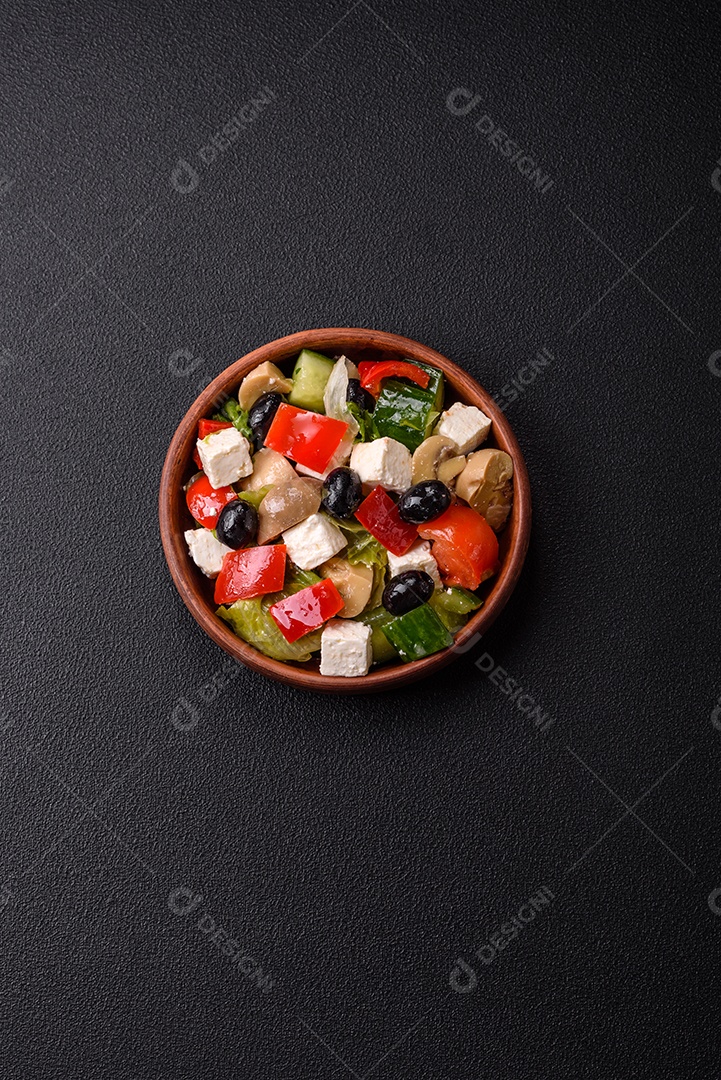 Deliciosa salada fresca e suculenta de pimentão, queijo, azeitonas, tomates, pepinos com sal e especiarias sobre um fundo escuro de concreto