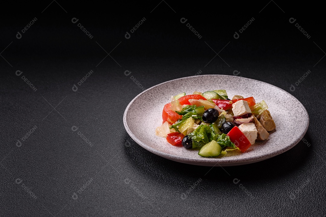 Deliciosa salada fresca e suculenta de pimentão, queijo, azeitonas, tomates, pepinos com sal e especiarias sobre um fundo escuro de concreto