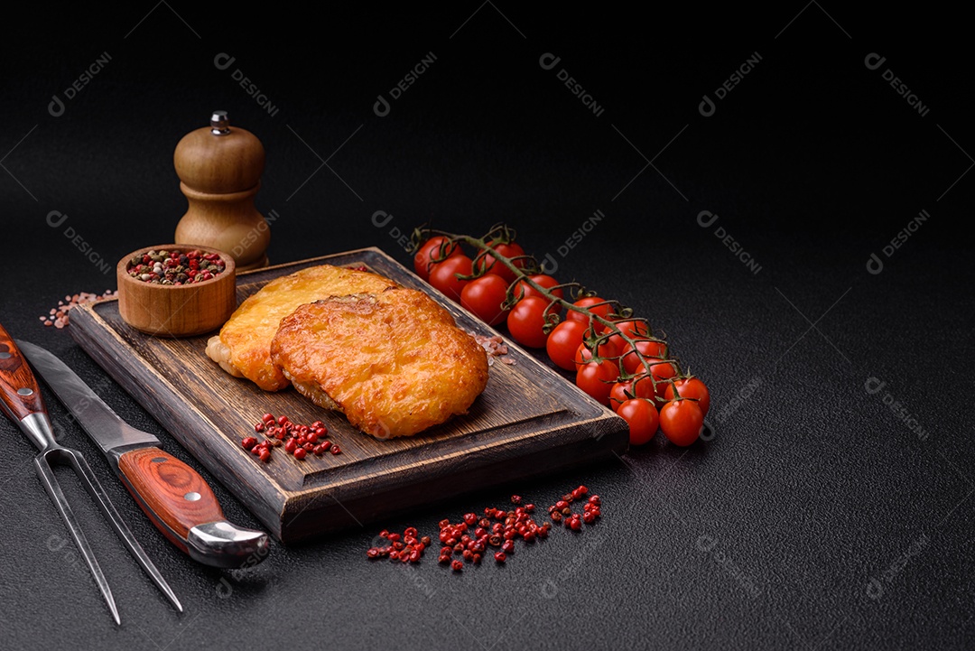 Deliciosa carne frita com mostarda Dijon com sal, especiarias e ervas sobre fundo escuro de concreto