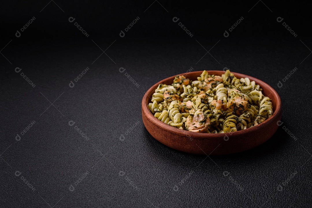 Deliciosa massa com espinafre, salmão, sal e especiarias sobre um fundo escuro de concreto