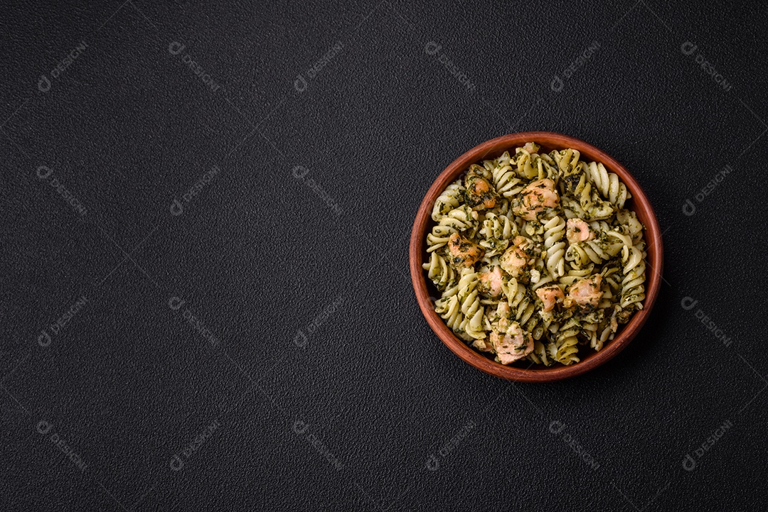 Deliciosa massa com espinafre, salmão, sal e especiarias sobre um fundo escuro de concreto