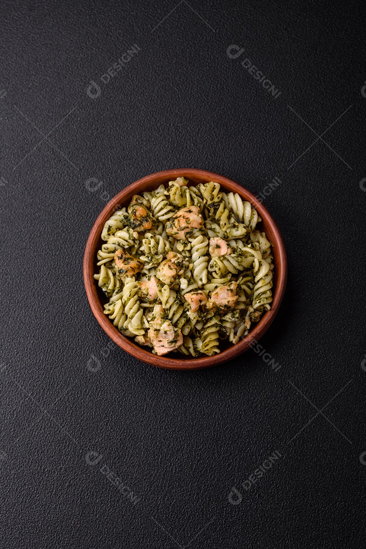 Deliciosa massa com espinafre, salmão, sal e especiarias sobre um fundo escuro de concreto