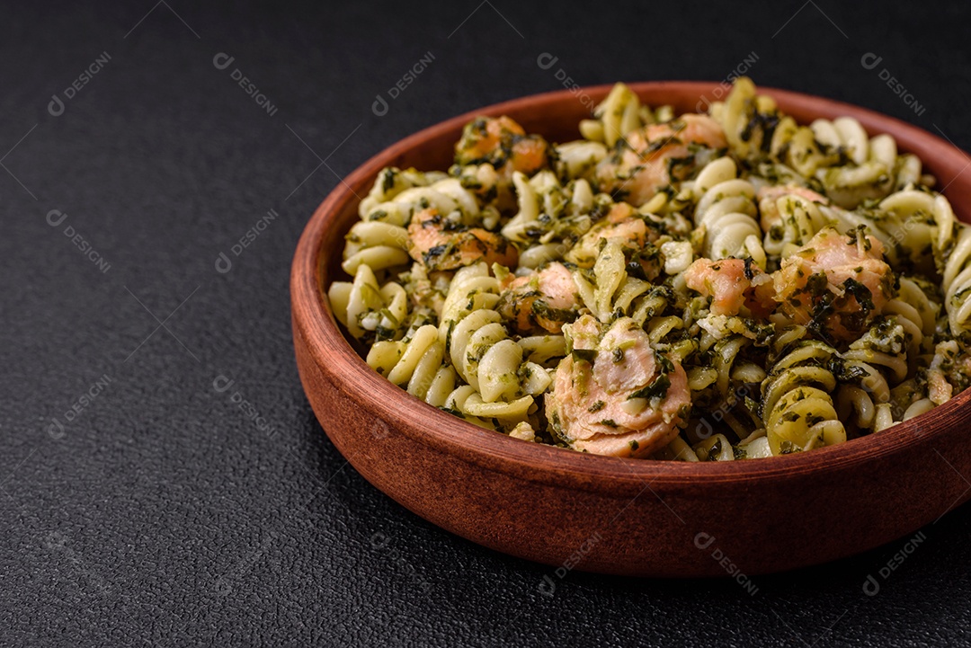Deliciosa massa com espinafre, salmão, sal e especiarias sobre um fundo escuro de concreto