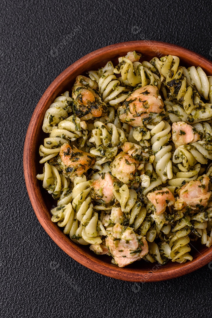 Deliciosa massa com espinafre, salmão, sal e especiarias sobre um fundo escuro de concreto