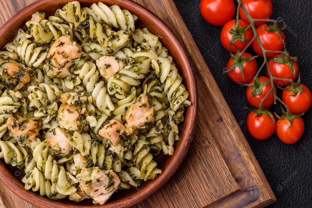 Deliciosa massa com espinafre, salmão, sal e especiarias sobre um fundo escuro de concreto