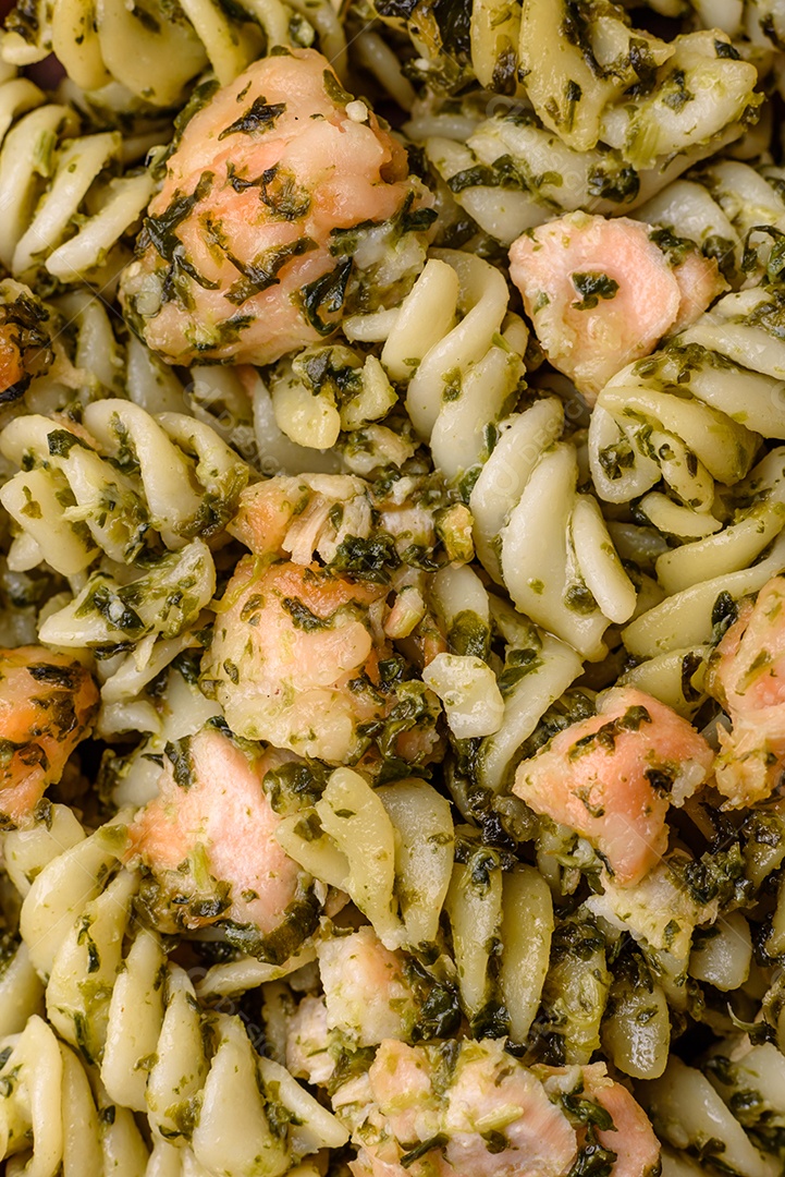 Deliciosa massa com espinafre, salmão, sal e especiarias sobre um fundo escuro de concreto